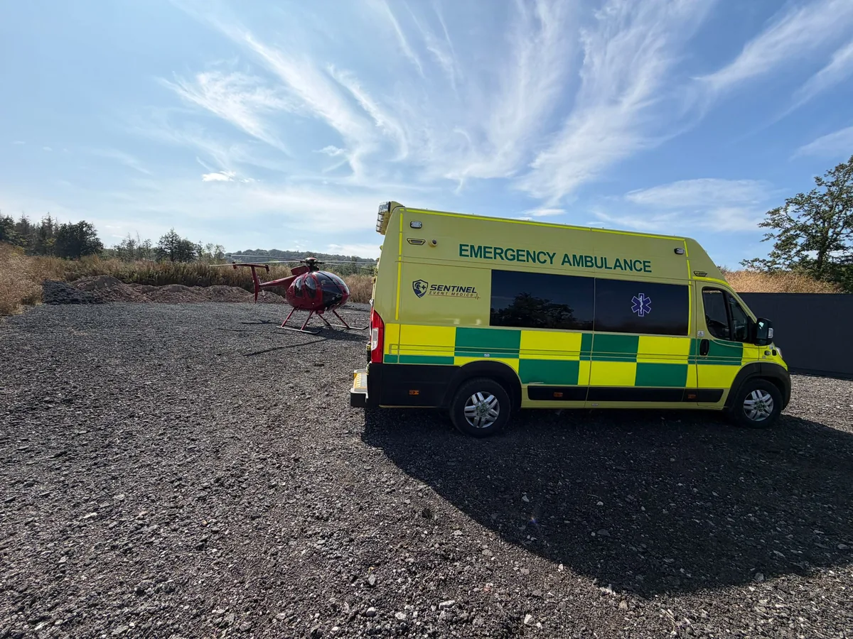 Sentinel Event Medics emergency ambulance on standby beside a helicopter during filming